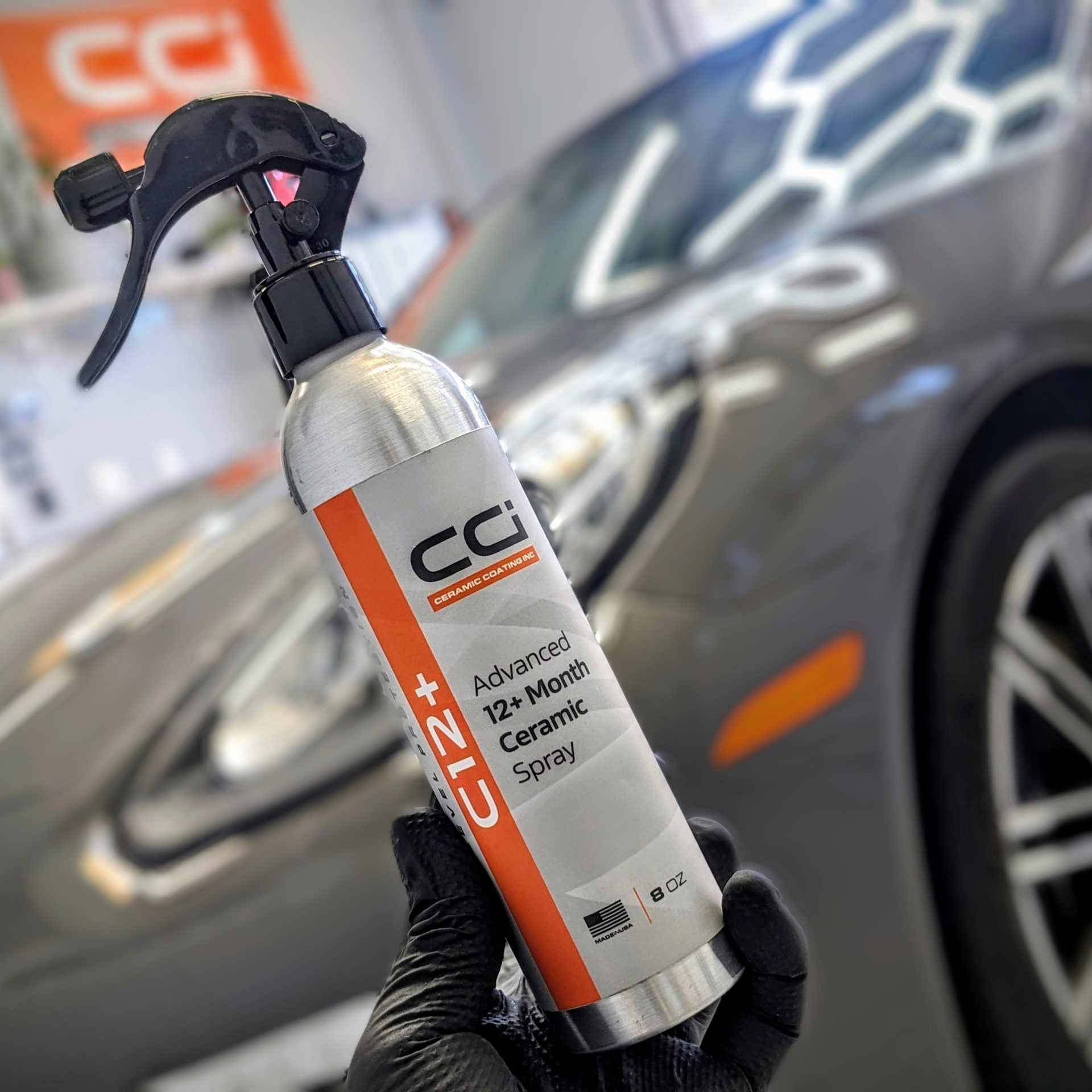 Spray bottle with 'CGI' branding held in front of a car